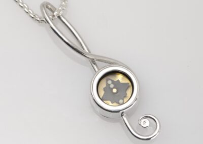 Working compass inside silver musical pendant with treble clef (G510)